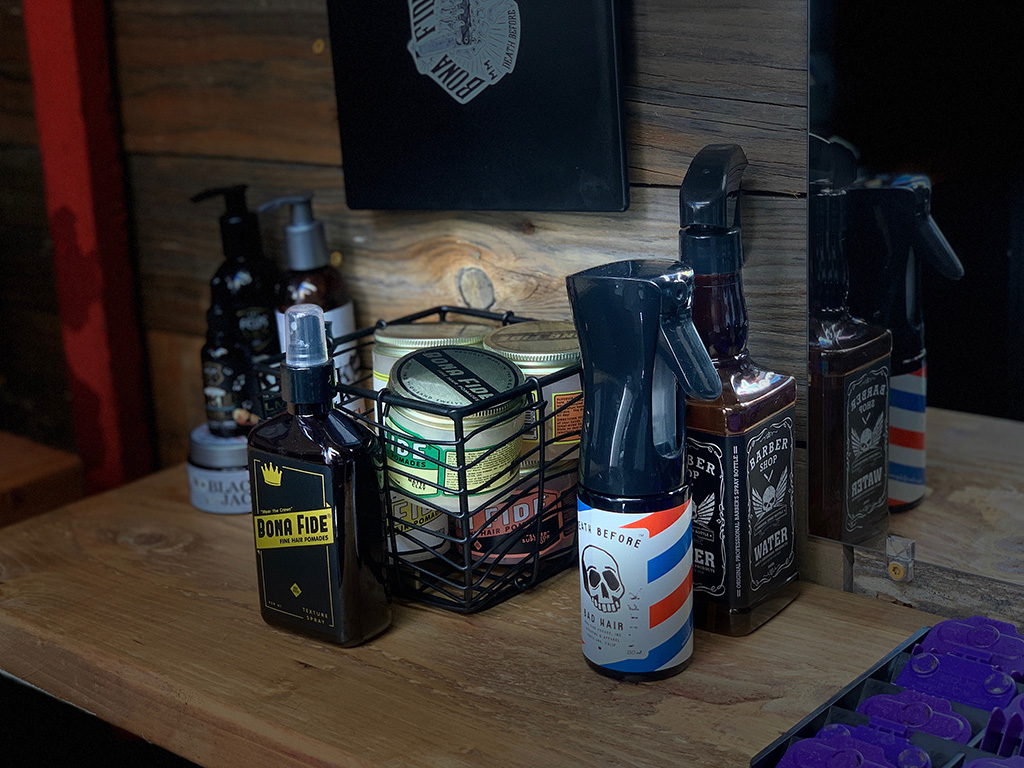 Photo depicting Back Bar Supplies including hair spray, water, and pomade spray
